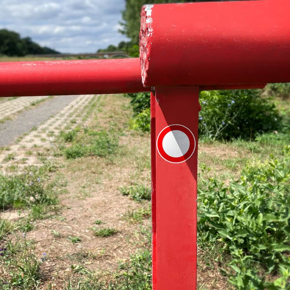 Verbotsschild-Aufkleber VZ 250 an roter Schranke auf ländlichem Weg befestigt