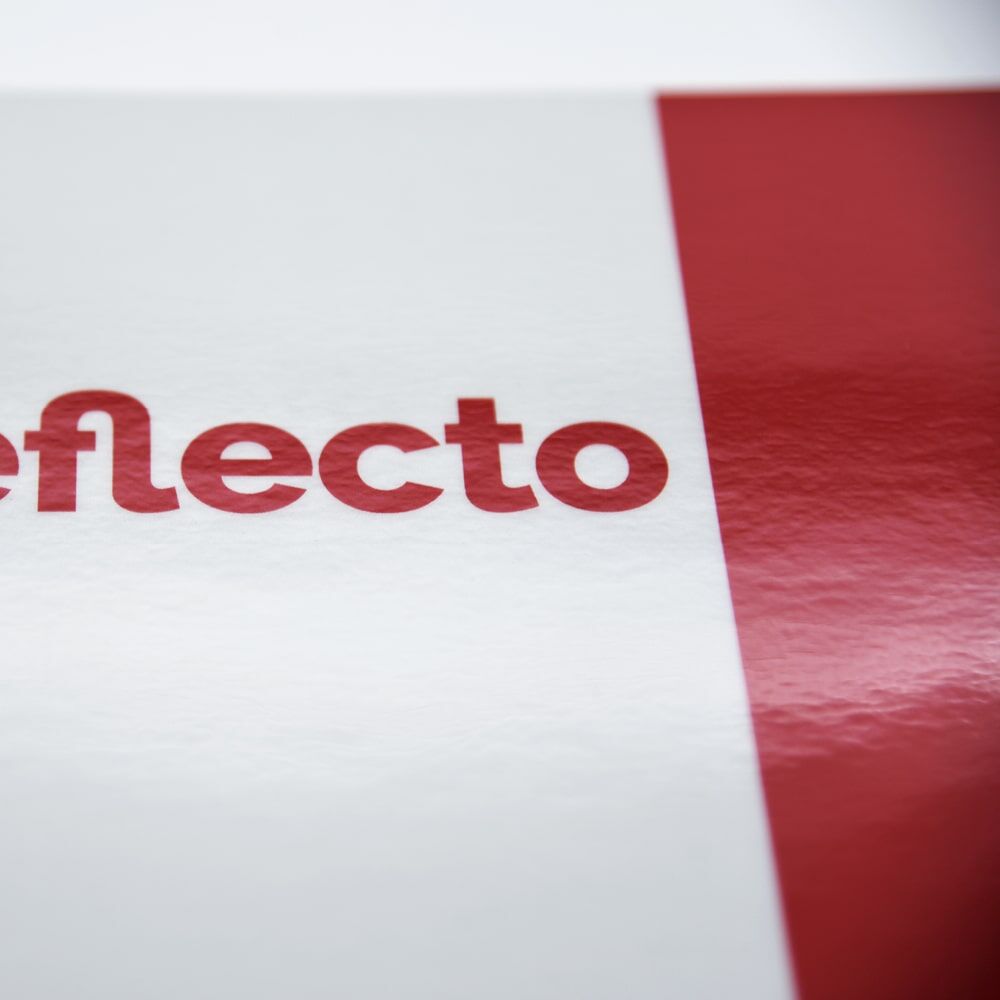 Detail: glänzende Folie mit reflecto-Logo auf weißem Streifen