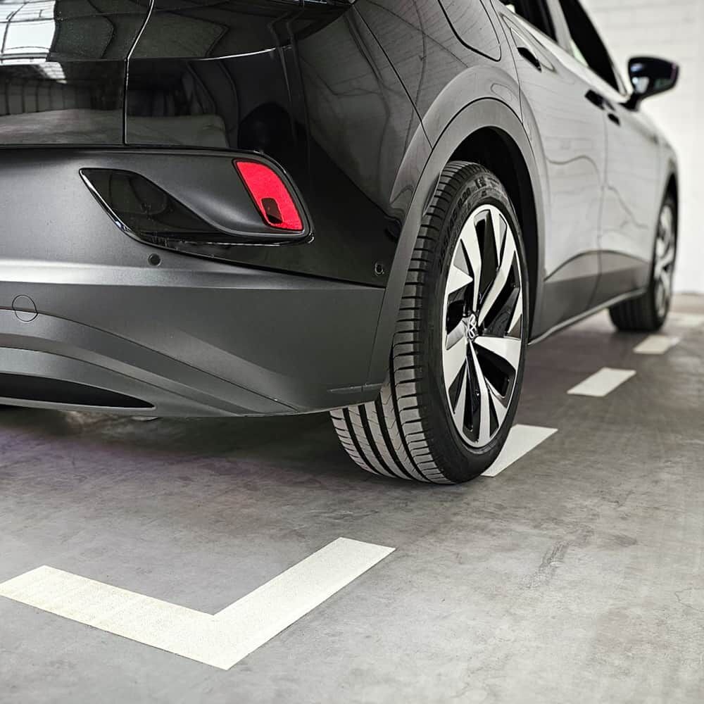 Schwarzes Fahrzeug steht auf 3M Stamark Parkplatzmarkierung in Innenbereich