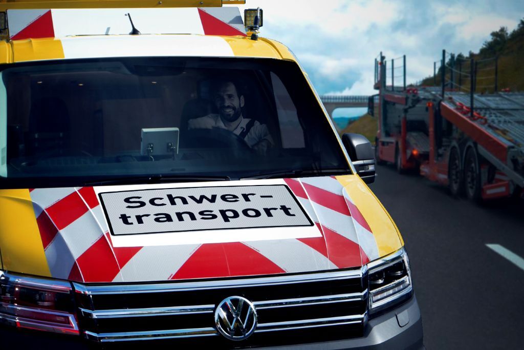 Frontansicht Begleitfahrzeug mit Schild „Schwertransport“ und beleuchtetem Warndisplay