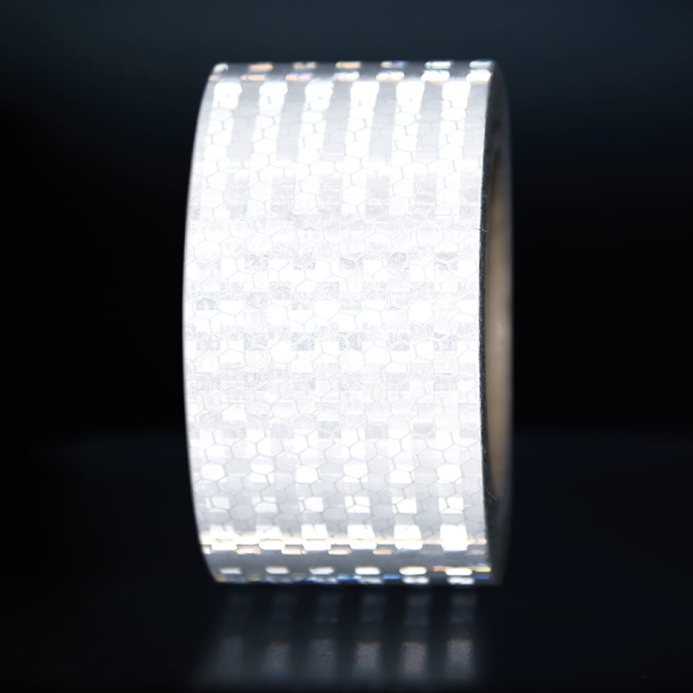 50 mm Rolle Avery Reflexband T-7500B weiß, reflektierend vor dunklem Hintergrund