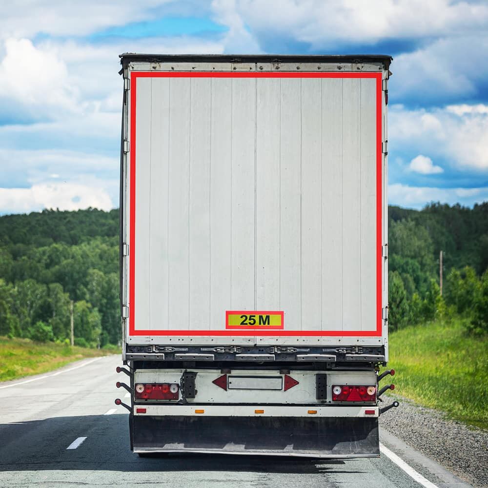 Lkw mit aufgeklebter „25 M“-Heckwarntafel auf freier Landstraße