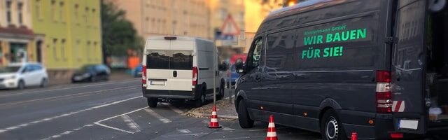Reflexfolie zur Fahrzeugbeschriftung und -gestaltung Ein Transporter mit reflektierender Werbeaufschrift parkt am Straßenrand.