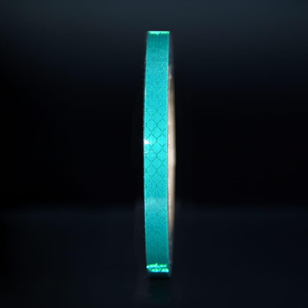 10 mm Rolle 3M Reflexband 3930 grün, reflektierend vor dunklem Hintergrund