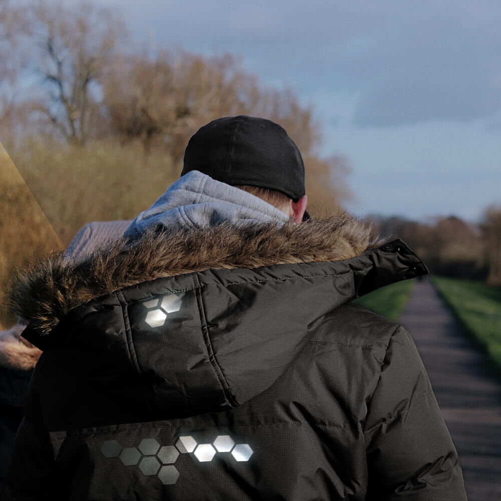Reflex-Waben auf schwarzer Winterjacke erhöhen Sichtbarkeit beim Spaziergang