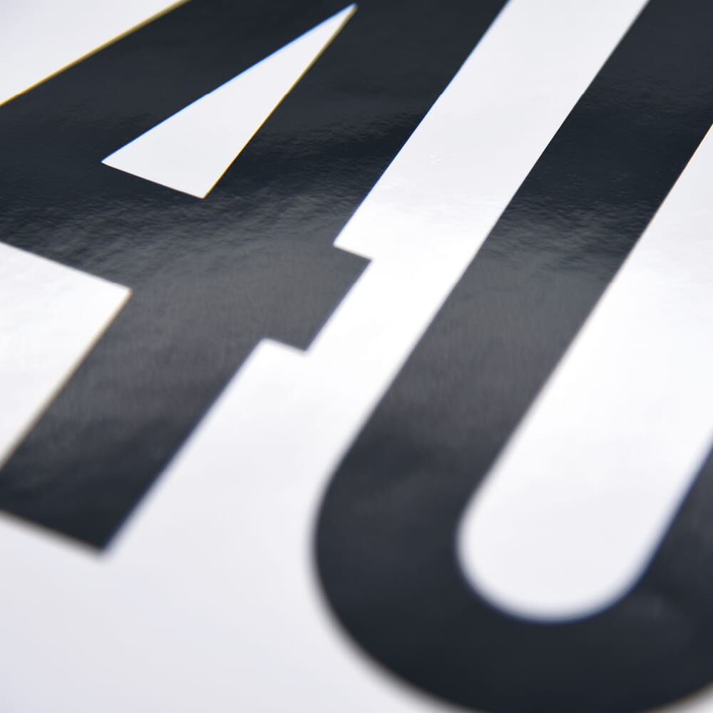 Makro: glänzende Front des 40-km/h-Aufklebers, schwarze Zahl auf weißer Folie