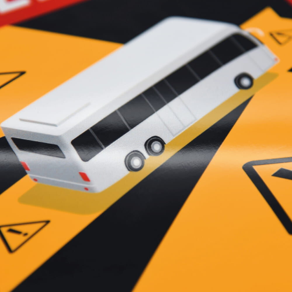 Nahaufnahme: Busmotiv auf Warnschild „Angles Morts“, glänzende Oberfläche