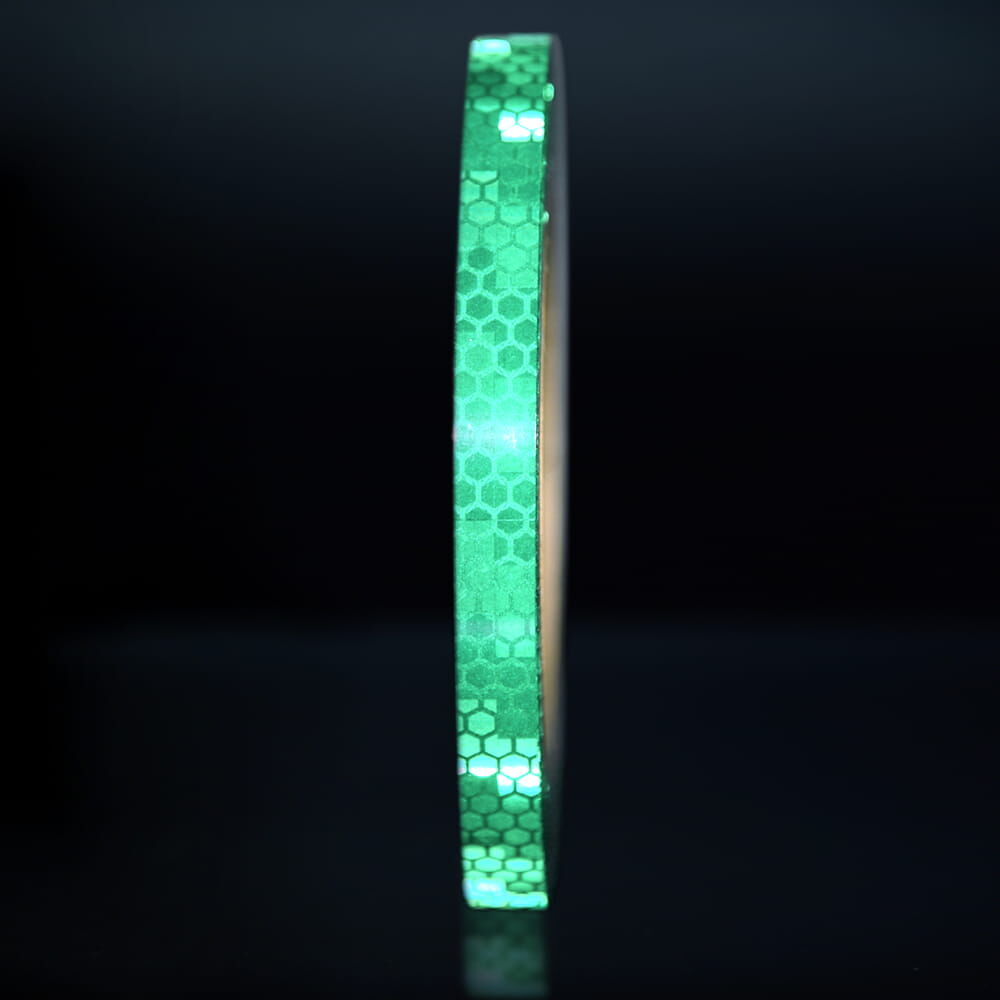 10 mm Rolle Avery Reflexband V-8000 grün, reflektierend vor dunklem Hintergrund