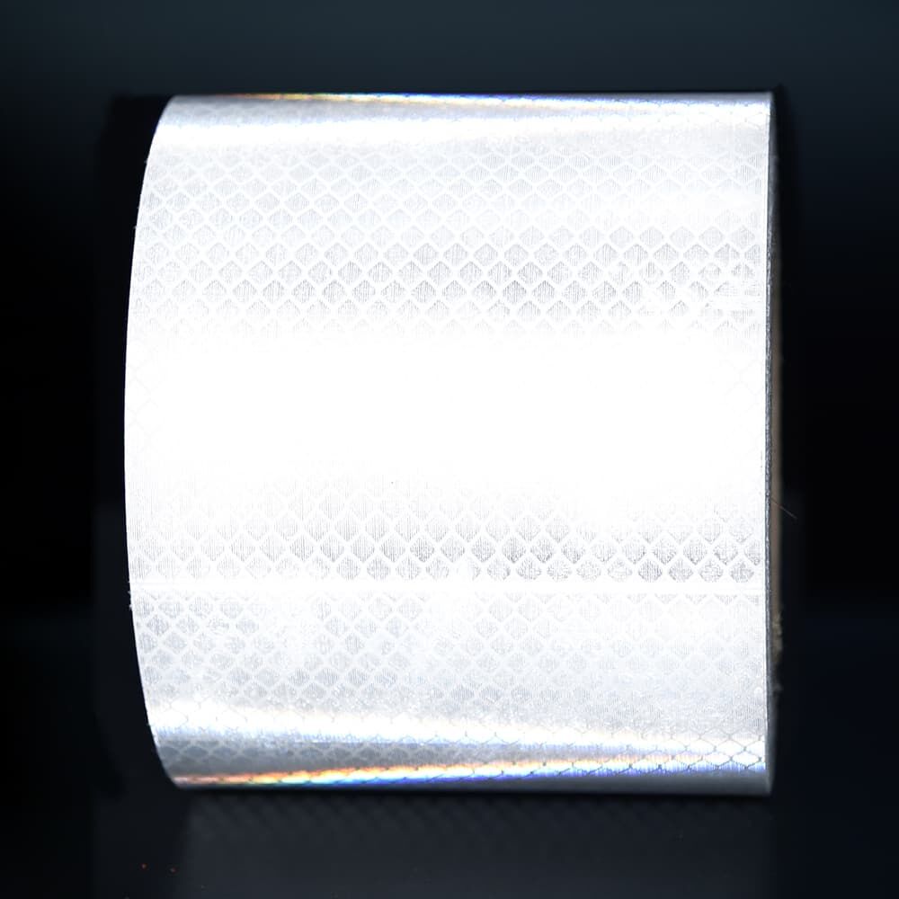 100  mm Rolle 3M Reflexband 4090 weiß, reflektierend vor dunklem Hintergrund