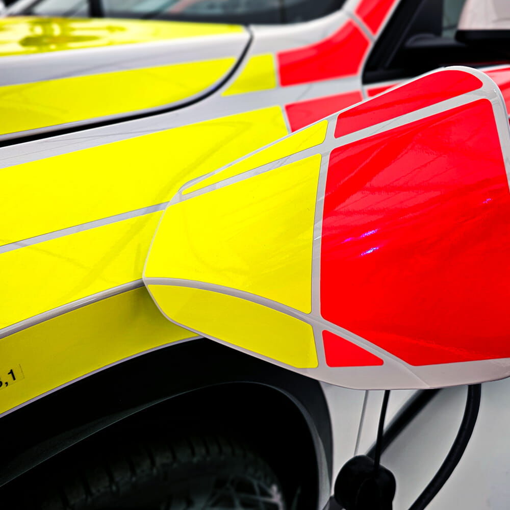 Detail gelbes und rotes Fluorfolien-Design 7510 Premium am Tankdeckel eines Fahrzeugs