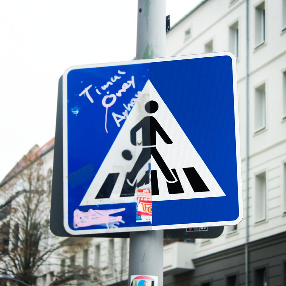 Vergleichsbild: Fußgängerüberwegschild zur Häfte mit Anti-Graffiti Film beklebt