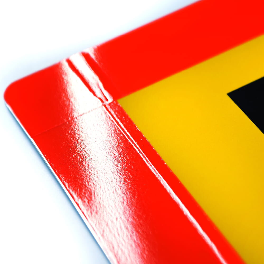 Glänzende rote Tafel-Ecke mit reflektierender Beschichtung, feine Prägung sichtbar
