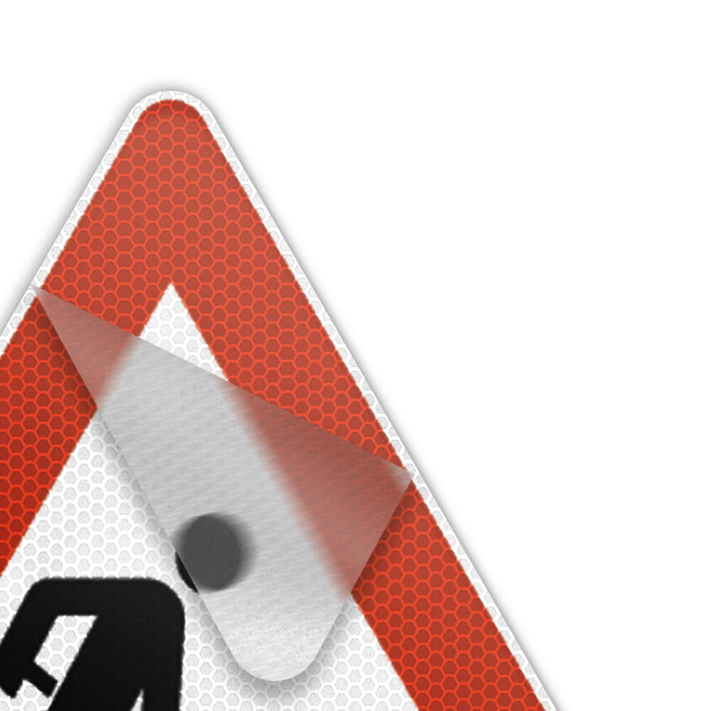 Ecke eines Baustellenschilds mit teilweise abgezogener Anti-Sticker-Folie.