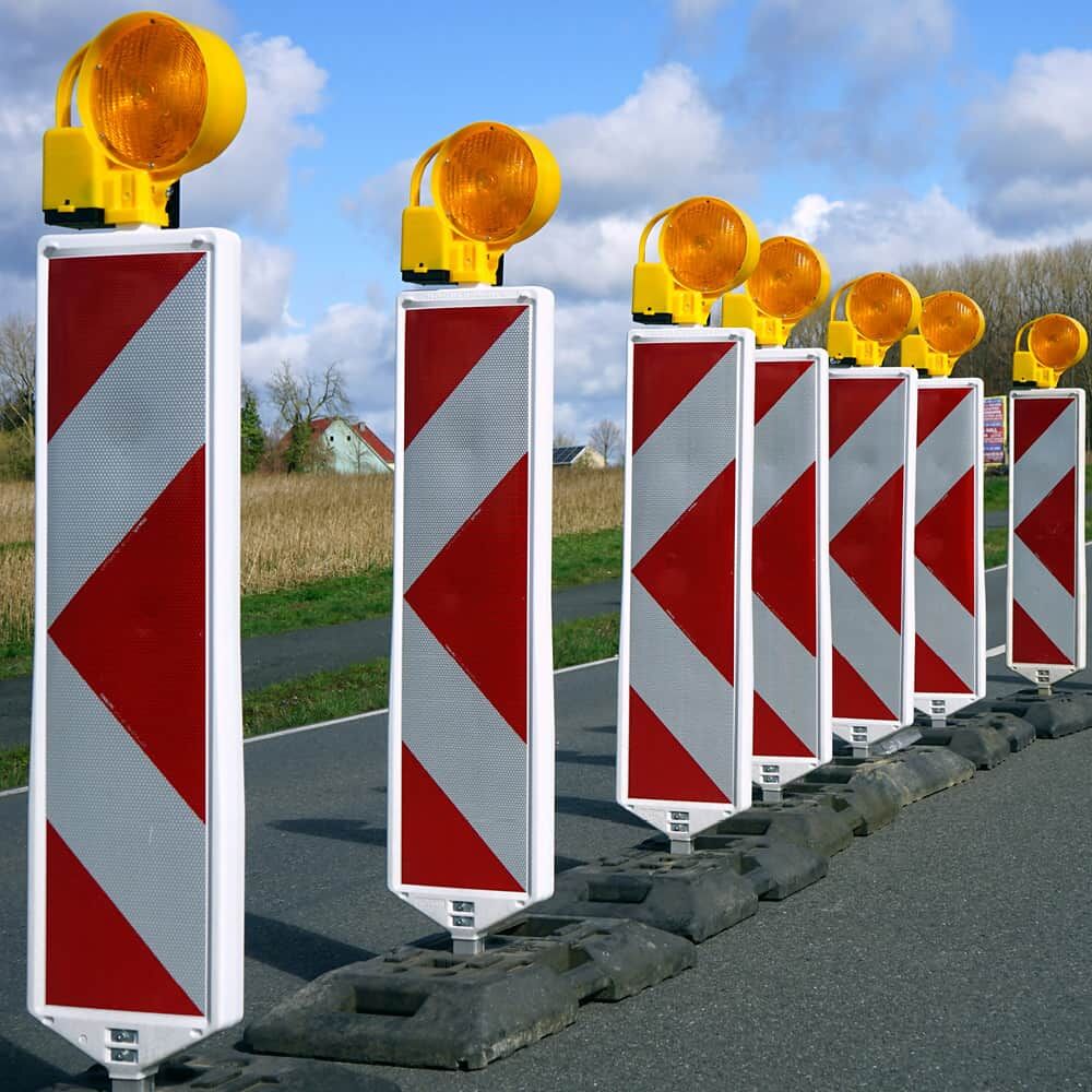 Aufstellung Warnbaken mit Pfeilfolie 5931M und gelben Warnleuchten an Landstraße