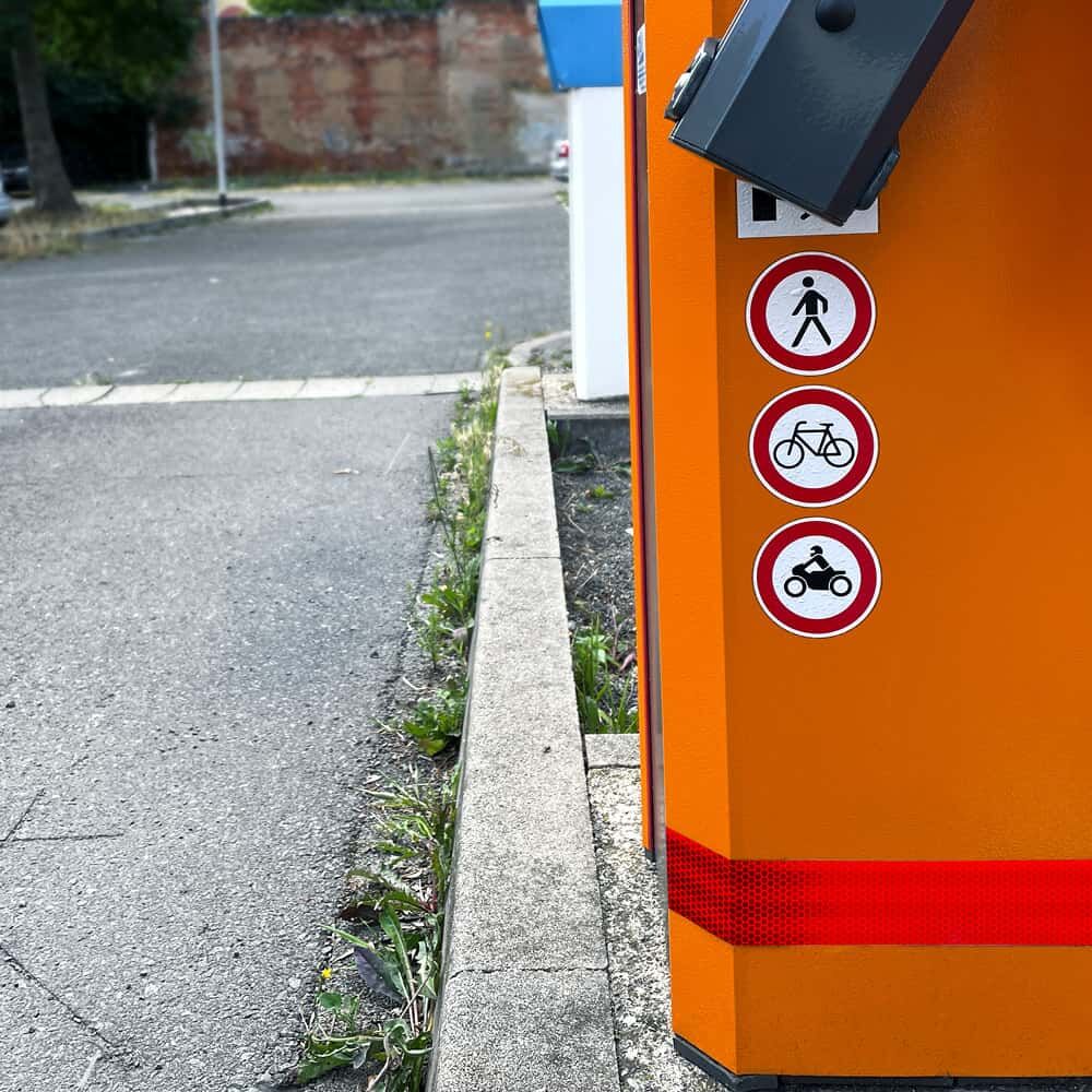 Rotes 3M 823i Reflexband an orangefarbener Parkschranken-Säule