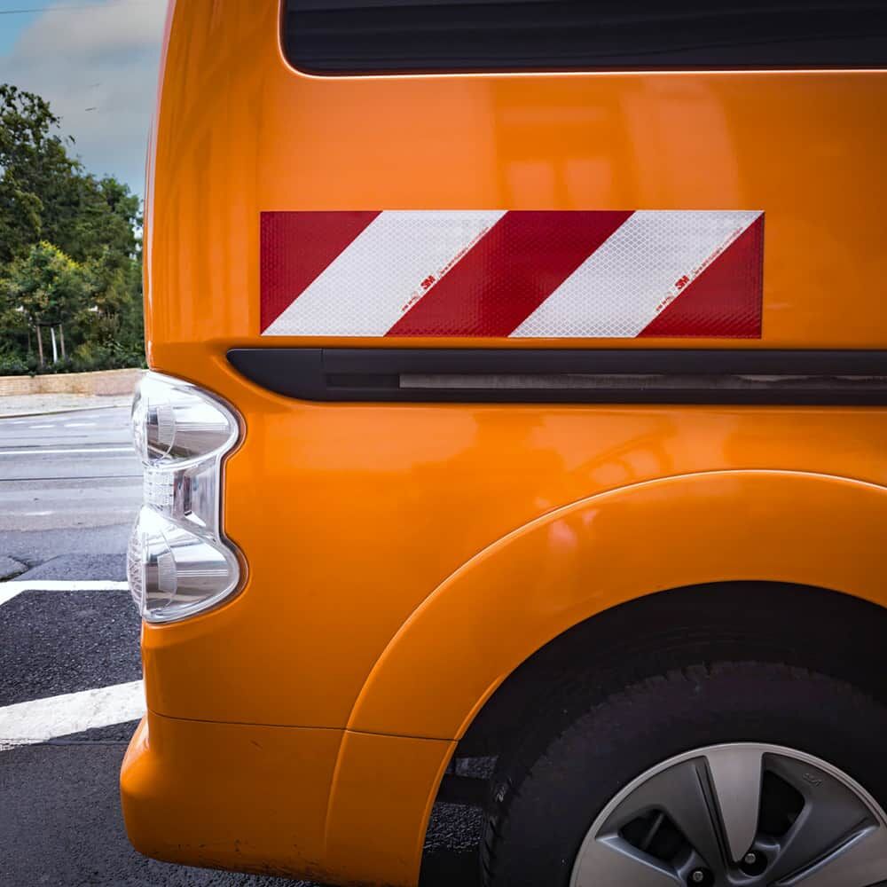 Seitliche Ansicht: linksweisender 3M 3410 Warnaufkleber am Fahrzeugkotflügel