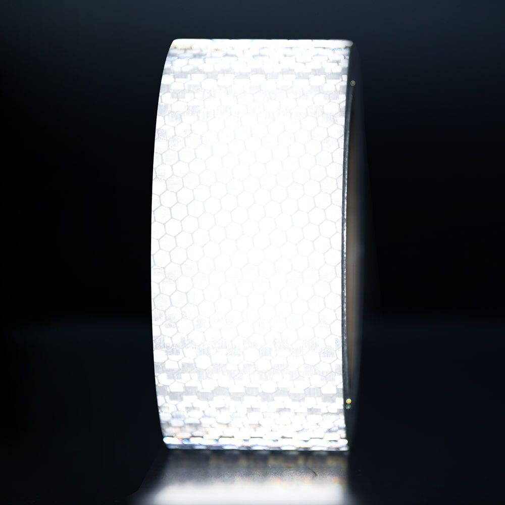 50 mm Rolle Avery Reflexband T-11500 OmniCube weiß, reflektierend vor dunklem Hintergrund