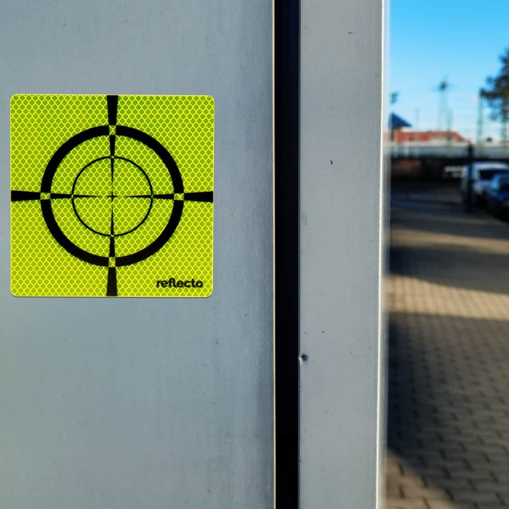 Zielmarke auf glatter Betonsäule im urbanen Umfeld, ideal für Vermessungspunkte