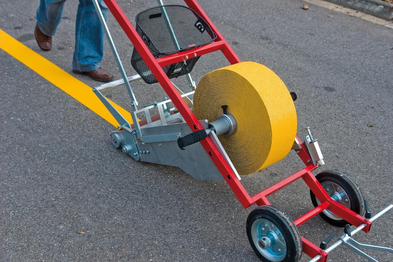 3M Folienverlegegerät MTA-II mit gelber Rolle im Einsatz auf der Straße