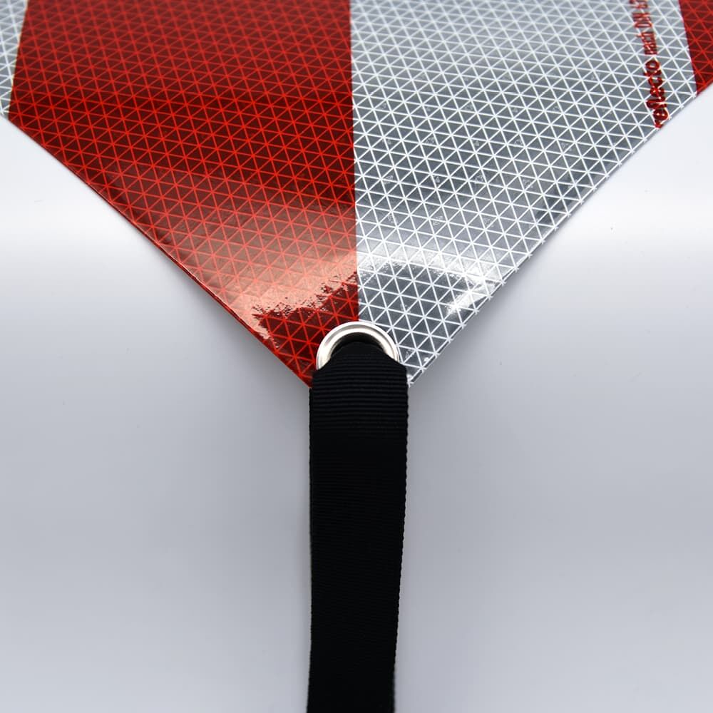 Spanngurt durch Öse eines reflektierenden Schildes geführt