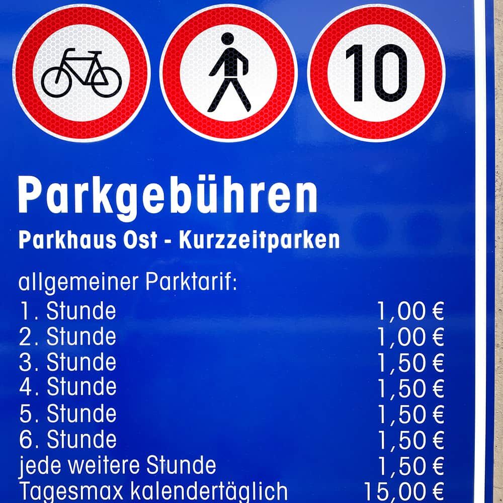 Runder Tempo-10-Aufkleber auf blauer Parkgebühren-Tafel