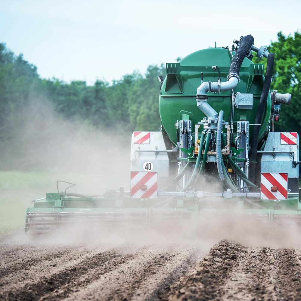 Güllefass mit 40-km/h-Aufkleber staubt über Acker – Geschwindigkeitsschild gut sichtbar