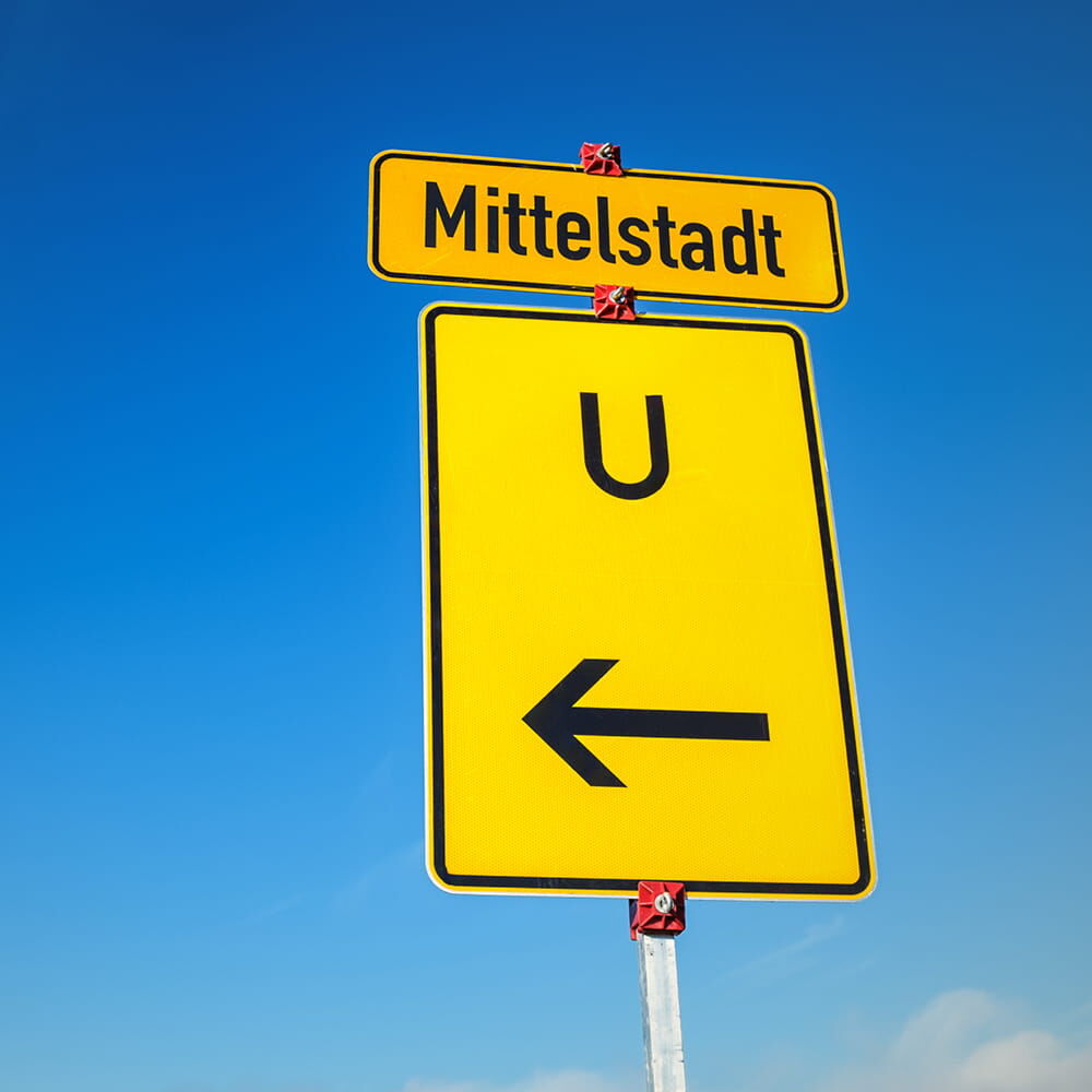 Umleitungsschild „U ←“ unter Ortstafel „Mittelstadt“, Einsatz der Folienfront im Feld