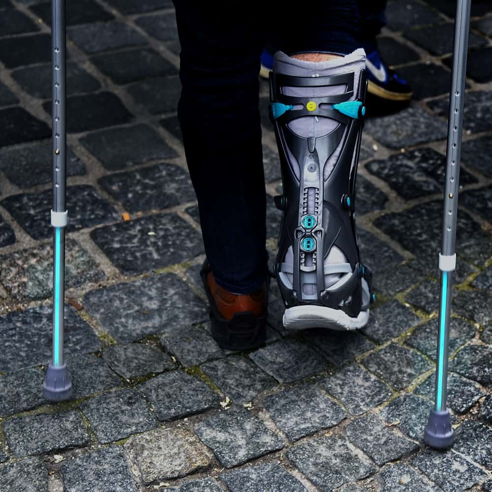 Gehstützen tragen azurblaues Reflexband 5600E für mehr Sicherheit auf Kopfsteinpflaster.