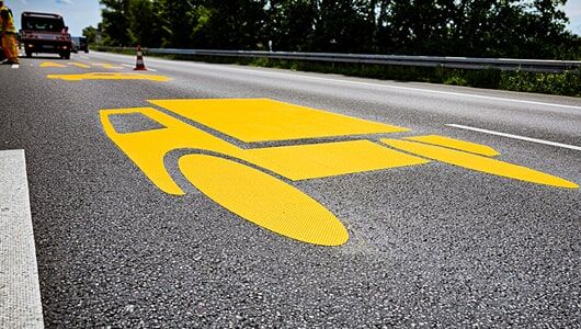 Abschnittstitelbild zu Piktogrammen für die Autobahn Das Bild zeigt ein LKW-Piktogramm auf der Autobahn verlegt, aus gelber. temporärer Fahrbahnmarkierungsfolie
