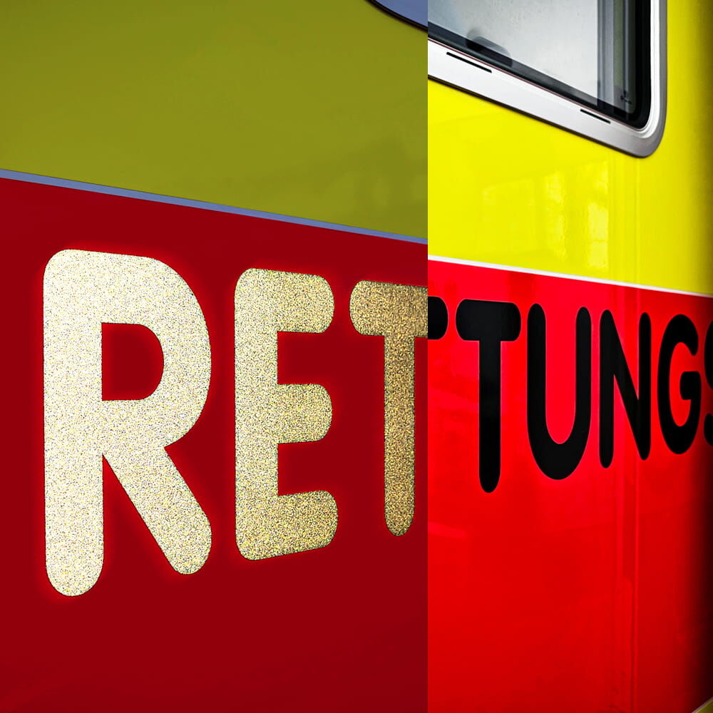 Nahaufnahme: Schriftzug „RETTUNG“ schwach reflektierend auf Rettungswagen