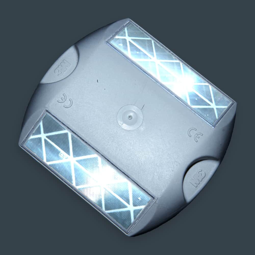 Weißer Straßenreflektor mit Reflexionseffekt auf dunklem Hintergrund