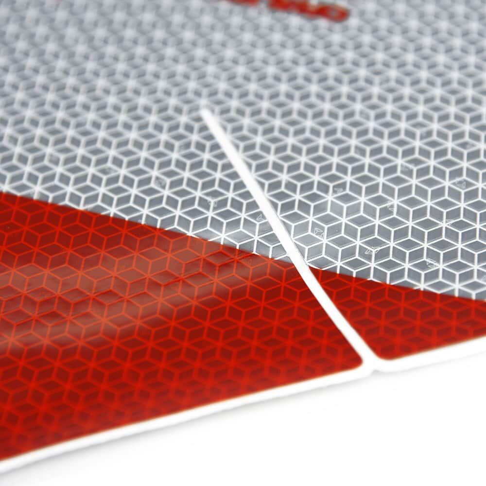 Nahaufnahme einer Warnmarkierung mit präzisem Entlastungsschlitz und Reflexstruktur