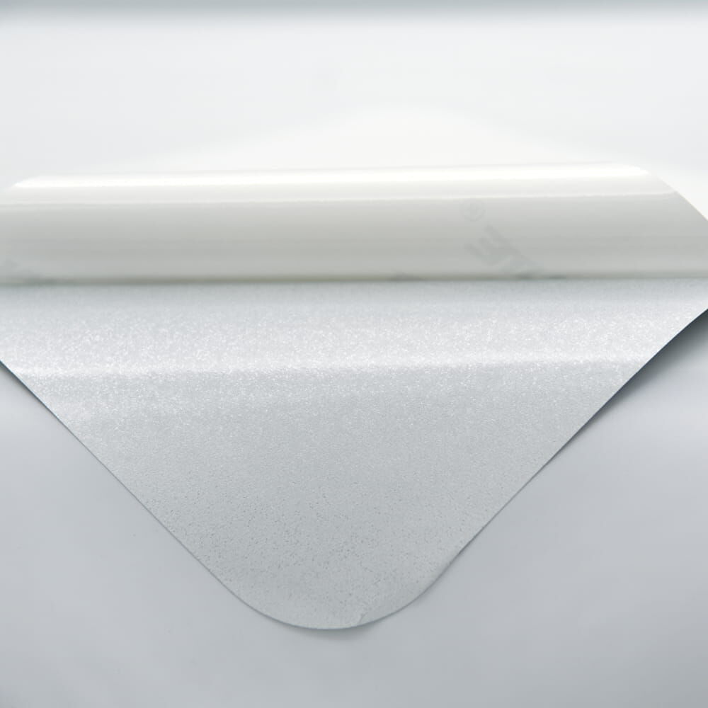 Rückseite leicht abgelöst, zeigt die strukturierte Klebefläche