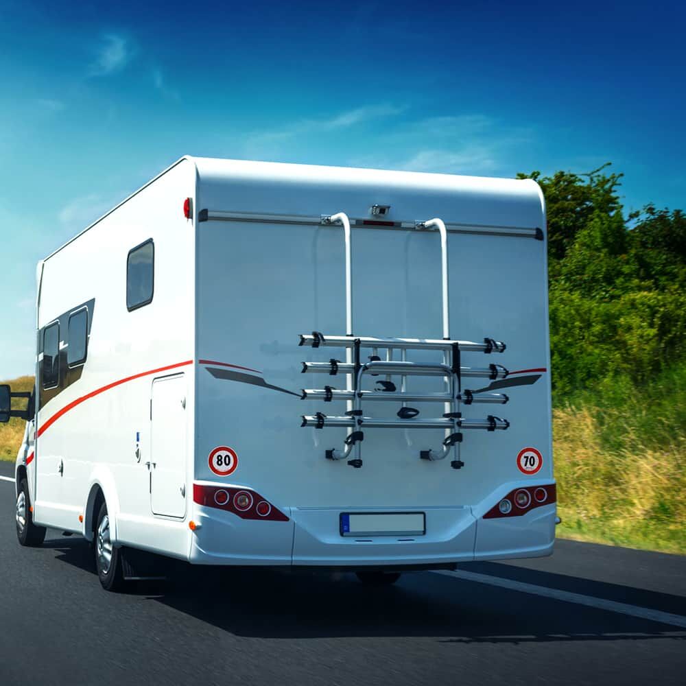 Reisemobil mit Fahrradbügel und 70-/80-km/h-Schildern auf Autobahn unterwegs