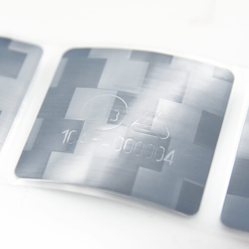 Weiße reflektierende Konturmarkierung mit Prüfzeichen in Nahaufnahme