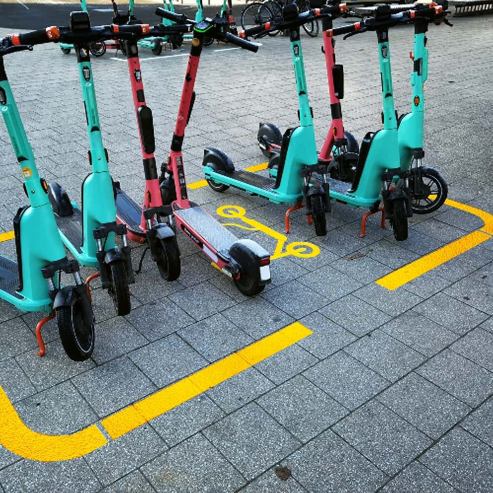 Abstellfläche für E-Scooter mit gelbem Markierungsrahmen und Symbol auf Pflaster